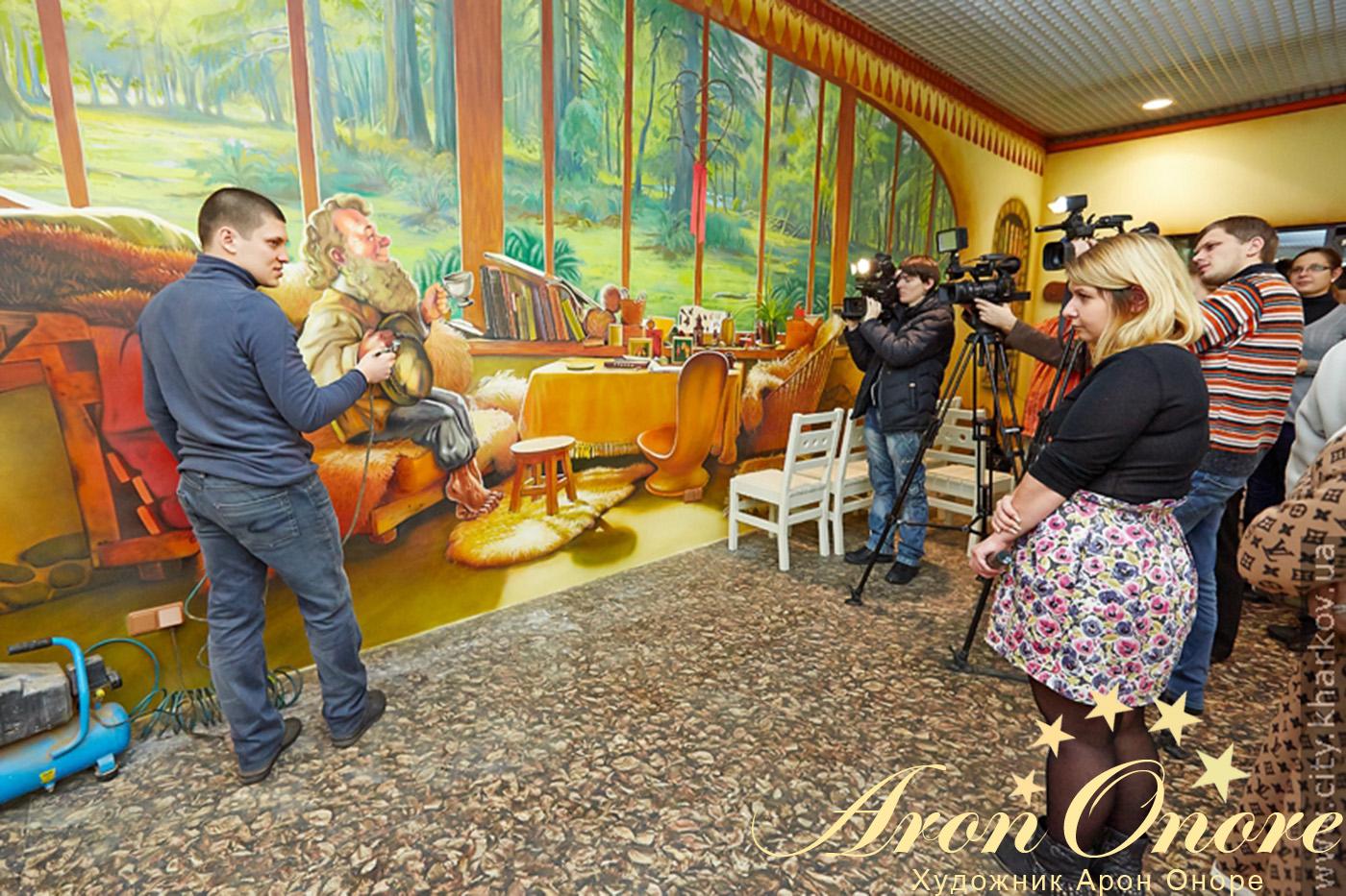 Художник Арон Оноре на фоне аэрографии в комнате Party-room