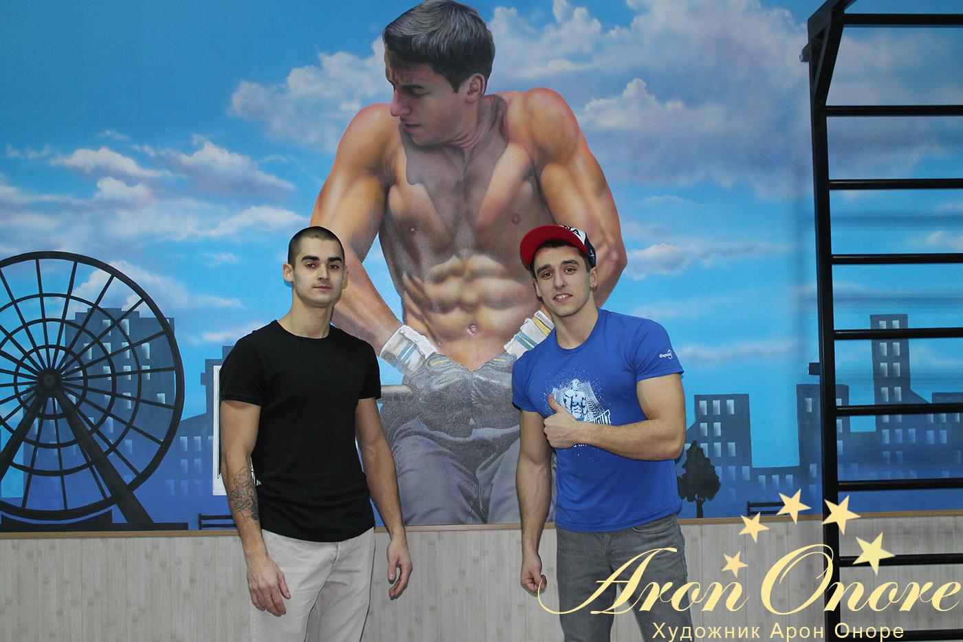Лидер движения Street Workout и художник аэрограф на фоне красивого рисунка на стене